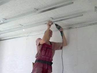 Muž opravuje stropní konstrukci pomocí vrtáku.
