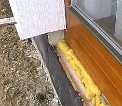 Žlutá izolační pěna v okenním překladi pro úsporu energie.