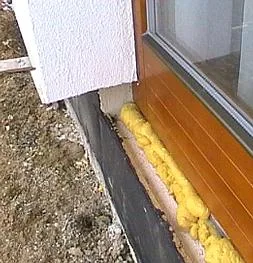 Žlutá izolační pěna v okenním překladi pro úsporu energie.
