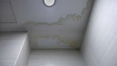Žluté skvrny na stropě v koupelně způsobené vlhkostí.