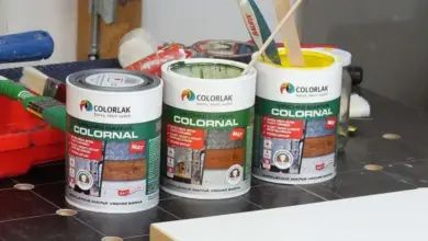 Tři plechovky barvy na polystyren s kartáči pro natírání.