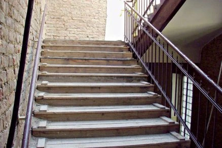 Kamenné schodiště s kovovými zábradlími pro bezpečnost.