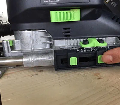 Přesné řezání dřevěného trámu pomocí elektrického pilového nástroje.
