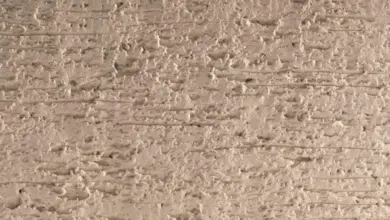 Texturovaný povrch polymerového písku s jemnými vodorovnými pruhy.