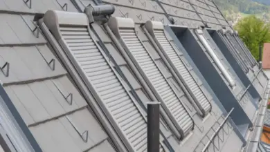 Řada střešních vikýřů s krycími clonami na šindelové střechě.