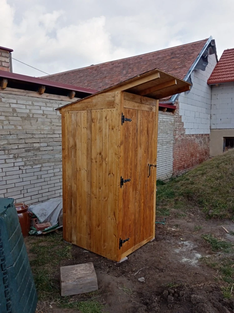 Dřevěná venkovní záchodová budova postavená vlastníma rukama.