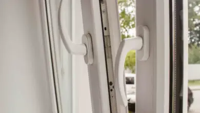 Bílá oválna okenní rukojeť s mechanismem pro přepnutí do zimního režimu.