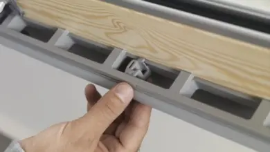 Detailní pohled na údržbu střešního okna s odhaleným vnitřním mechanismem.