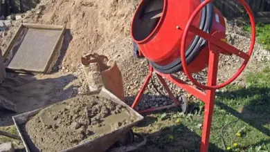 Červený betonový míchač s vápennou maltou v vozíku.