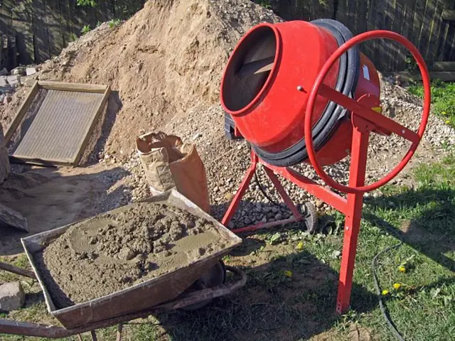 Červený betonový míchač s vápennou maltou v vozíku.