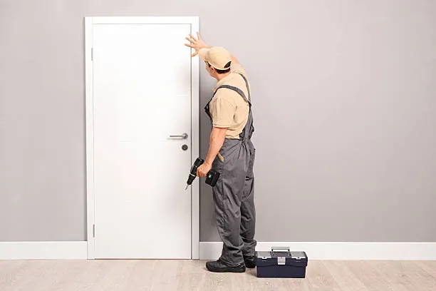 Carpenter installing door