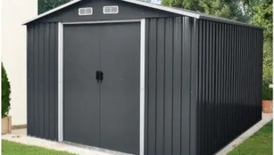 Černá kovová zahradní kůlna s dvířky na větrání.