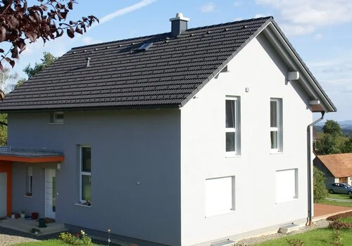 Moderní dům s komínovou trubicí na střeše.
