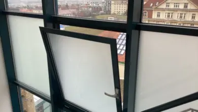 Otevřené okno na únikové cestě s výhledem do města.