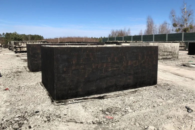 Velký betonový blok pro samostatně vyrobený septik na štěrkové ploše.