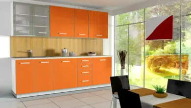 Moderní kuchyň s oranžovými dolními skříněmi a šedými horními.