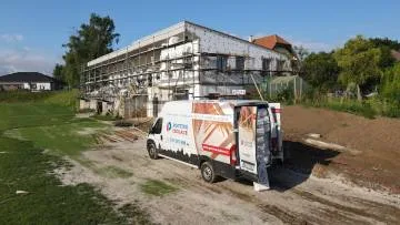 Staveniště s vozem pro instalaci tepelne izolace.
