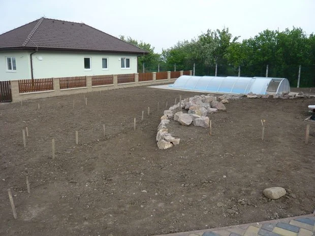 Příprava pozemku pro zahradu s kameny a skleníkem.