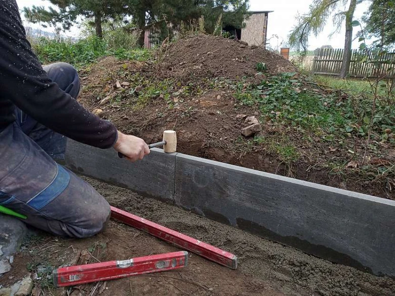 Montáž obrubníku pro chodník s úrovní a kladivem