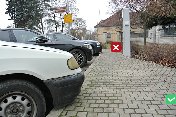 Přistavená auta vedle dlažebního chodníku v městském prostředí.