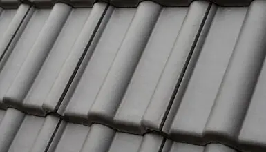 Detailní záběr na šedé valbové střechové panely.