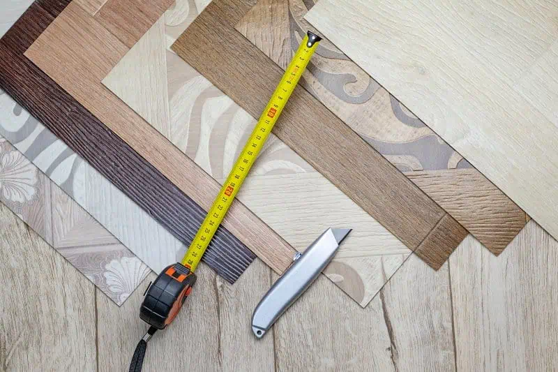 Výběr podlahových materiálů s měřicí páskou pro přípravu základny.