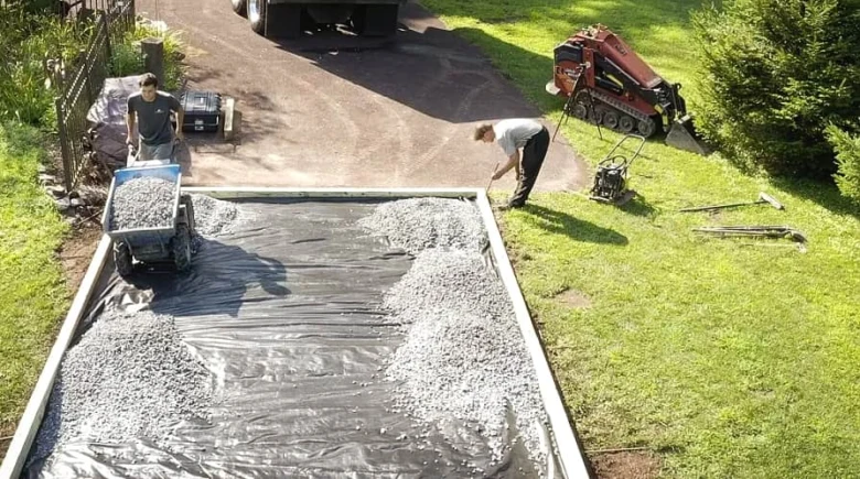 Práce s geotextilií pod betonový základ s vrstvou štěrku.