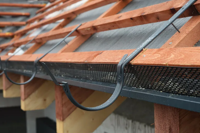 Detailní pohled na instalaci hřebenu s mřížkou k dřevěným trámem.