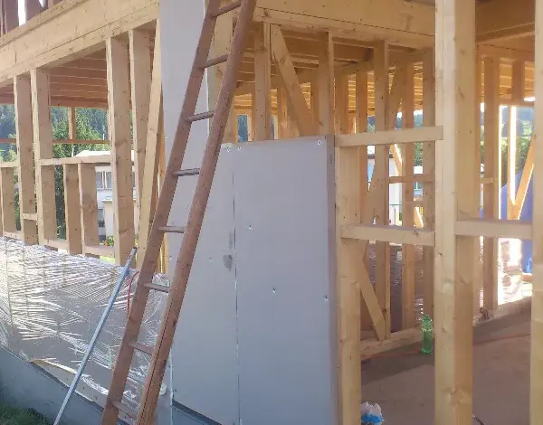 Stodola v dřevěném rámu s instalací izolace na stavbě.