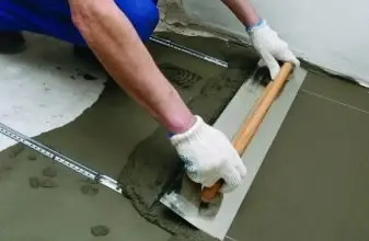 Muž vyrovnává podlahu s betonem pomocí pravítka.