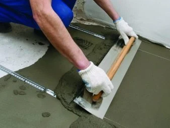 Muž vyrovnává podlahu s betonem pomocí pravítka.