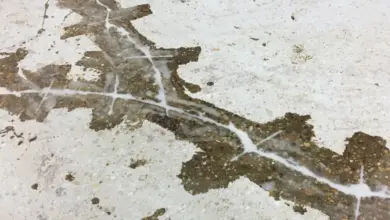 Nerovná betonová podlaha s prasklinami a skvrnami před vyrovnáním.