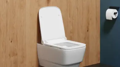 Bílá závěsná toaleta namontovaná na dřevěné stěně s instalací.