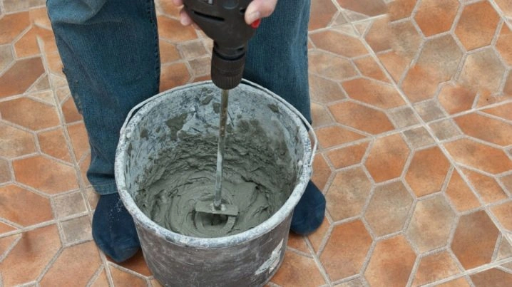 Míchání omítky v kbelíku pomocí elektrického míchačky.