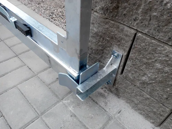 Detailní pohled na montážní úchyty posuvné brány ke zdi.