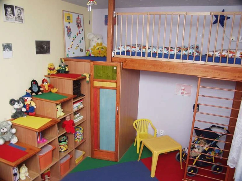 Ložní místo pod stropem s herním prostorem v dětském pokoji.