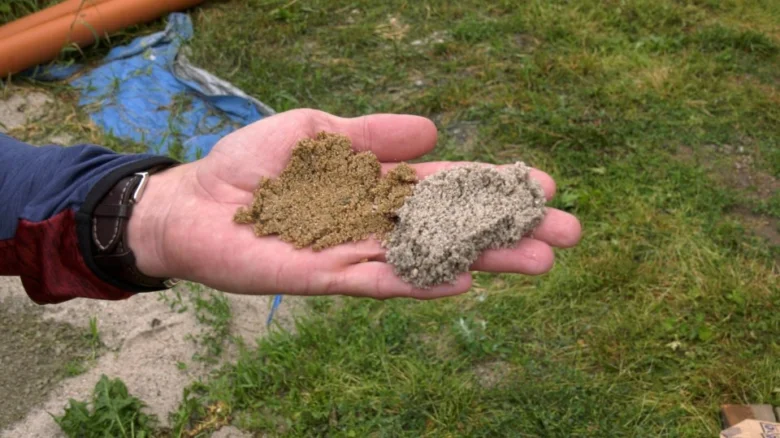 Ruce drží dva vzorky stavebního materiálu pro přípravu cementového mléka.
