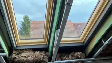 Krovové trámy s izolací mezi nimi v interiéru.