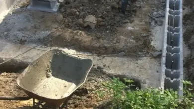 Stavba betonového základu z bloků v jámě s nářadím.