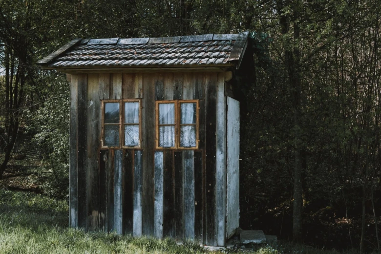 Dřevěná kulna postavená vlastními rukama uprostřed lesa.