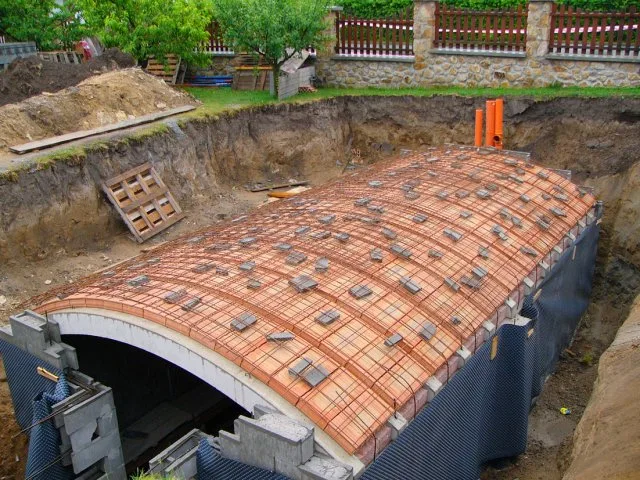 Stavba cihlové klenby ve sklepě s výztuží a dlaždicemi.