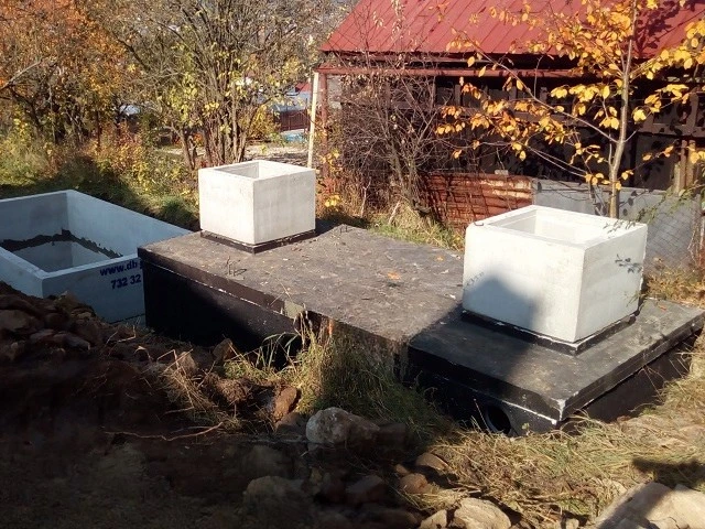 Betonové komponenty septiku postavené vlastními rukama venku.