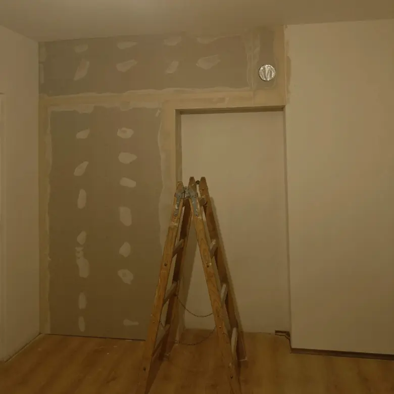 Stavba sádrokartonu v interiéru s leštěným podlahovým povrchem.