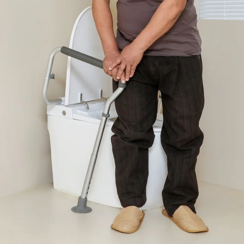 Elderly person with grab bar near toilet