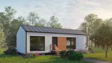 Moderní přístavba k domu s velkými okny v zeleném prostředí.