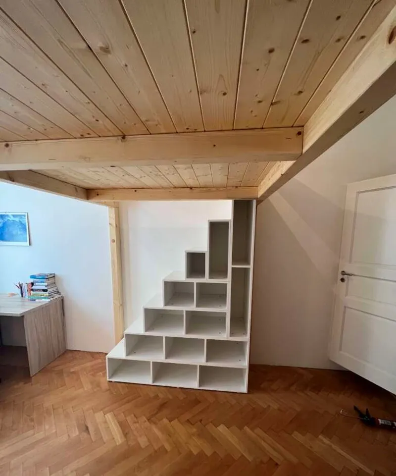 Modulární police pod stropem pro úložný prostor v ložnici.