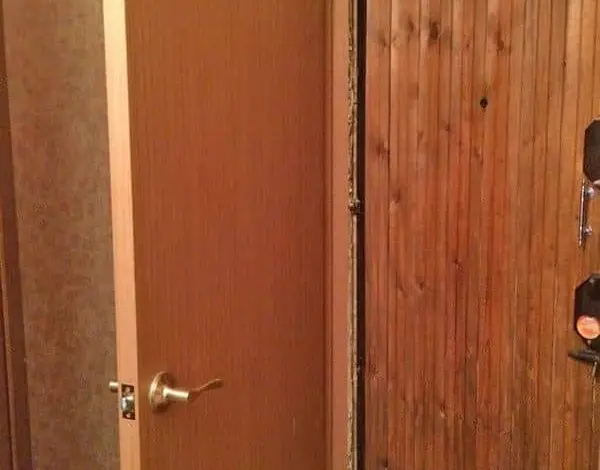 Otevřené vnitřní dveře s viditelnou mezerou pod nimi.