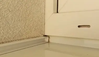 Detail sklonu okenního parapetu pro odvod vody u zdi.