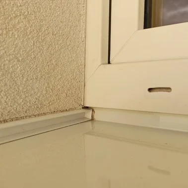Detail sklonu okenního parapetu pro odvod vody u zdi.