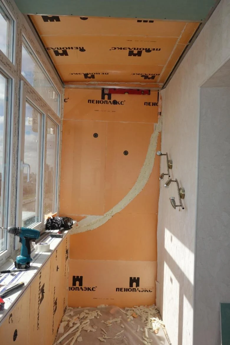 Balkon se izolovalý oranžovou pěnou a nástrojem na okně.